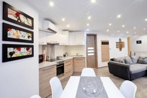 a kitchen and living room with a table and a couch at Főtér Apartman in Villány