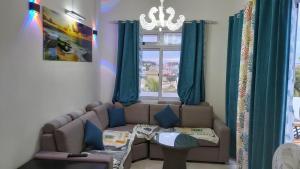 ein Wohnzimmer mit einem Sofa und einem Fenster in der Unterkunft Krishangel Beach Apartment in Flic-en-Flac