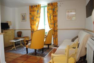 1 dormitorio con sillas amarillas, 1 cama y ventana en Mas de Bouvau, en Violès