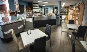 a restaurant with tables and chairs and a counter at Albavillage Rooms & Camping in Alba