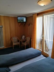 A bed or beds in a room at Petit Helvetia Budget Hotel