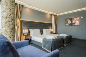 索非亚Budapest Hotel - Free Parking的一间带一张床和两把椅子的酒店房间