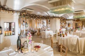 jadalnia z białymi stołami, krzesłami i żyrandolami w obiekcie Borgo Egnazia w mieście Savelletri di Fasano