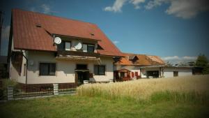 ein Haus mit rotem Dach auf einem Feld in der Unterkunft Privat Luna in ľubeľa