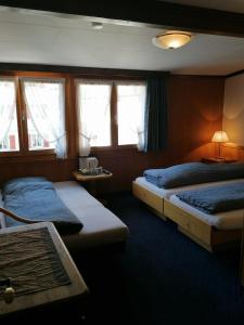 A bed or beds in a room at Petit Helvetia Budget Hotel