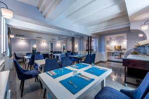 a restaurant with tables and chairs and a bar at Hotel Domino in Opatija
