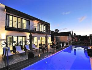 a house with a swimming pool in front of a house at DysArt Boutique Hotel - Solar Power in Cape Town