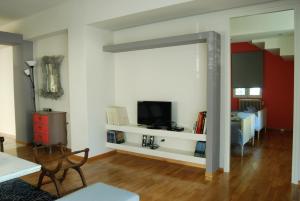 アテネにあるAffordable luxury garden apartmentのリビングルーム(壁にテレビ付)