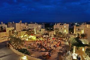 a group of people walking around a city at night at Borgo Egnazia in Savelletri di Fasano