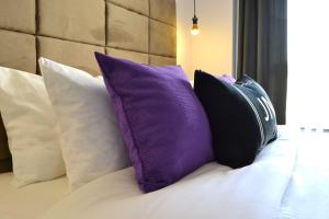 a bunch of pillows sitting on a bed at JN Boutique Apartments in Bucharest