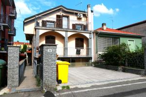 ペーロにあるBnbook Olona-Fiera Milanoの黄色いゴミ箱が前にある家