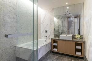 Un baño con bañera, lavabo y espejo. en Dorsett Tsuen Wan, Hong Kong, en Hong Kong