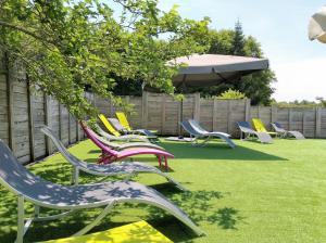 a group of lawn chairs sitting on the grass at Camping familial les chalets d'Uza in Uza