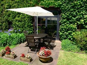 a table and chairs with an umbrella in a garden at Remanso del río Saja in Renedo +149 photos