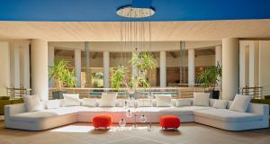 a living room with a white couch and red chairs at Capovaticano Resort Thalasso Spa in Capo Vaticano