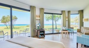 a bedroom with a bed and a view of the ocean at Capovaticano Resort Thalasso Spa in Capo Vaticano
