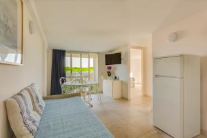 a living room with a couch and a refrigerator at Oltremare Appartamenti in Principina a Mare