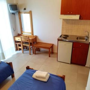 a room with a kitchen and a table with a bed at Hotel Thisvi in Stalís