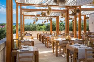 a restaurant with wooden tables and chairs and tablesearcher at Borgo Egnazia in Savelletri di Fasano