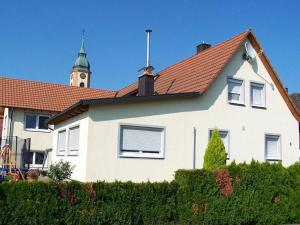 una casa bianca con una torre dell'orologio sullo sfondo di Ferienwohnung Sandhaas a Ringsheim