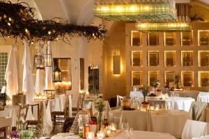 a dining room with white tables and chairs with lights at Borgo Egnazia in Savelletri di Fasano