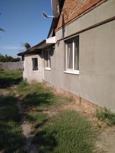 uma casa com janelas do lado em Дом em Okhtyrka