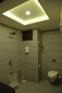 a bathroom with a toilet and a shower and a sink at Hotel Roma Kristo in Dwarka