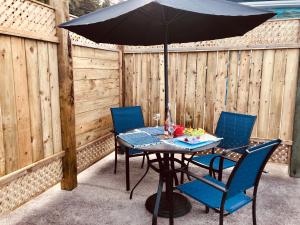 a table and chairs with an umbrella on a patio at Suite 1 Flèche du fjord vue Saguenay Monts Valin in Saint-Fulgence