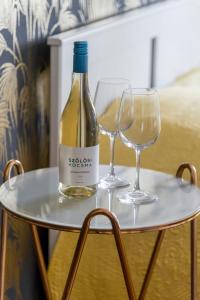 a bottle of wine and two glasses on a table at Central Apartman in Budapest