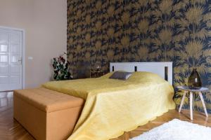 ein Schlafzimmer mit einem Bett mit gelber Tagesdecke in der Unterkunft Central Apartman in Budapest
