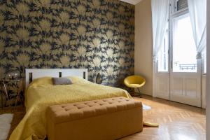 a bedroom with a bed with a yellow blanket and a window at Central Apartman in Budapest