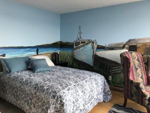 a bedroom with a bed and a painting of a boat at Suite 1, Flèche du fjord, vue Saguenay, Mont Valin in Saint-Fulgence