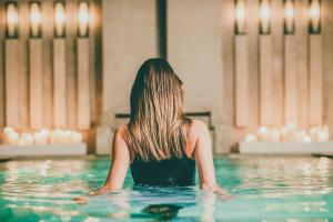 a woman in the water in a swimming pool at Borgo Egnazia in Savelletri di Fasano
