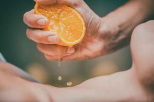 a person holding an orange with water dripping from it at Borgo Egnazia in Savelletri di Fasano