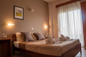 een slaapkamer met een bed met handdoeken erop bij Hotel Akti in Leptokarya
