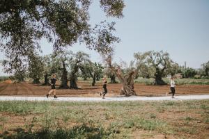 a group of people walking a dog on a trail at Borgo Egnazia in Savelletri di Fasano