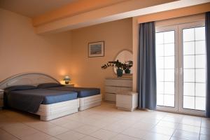 a bedroom with a bed and a window at Creta Hotel in Agios Nikolaos