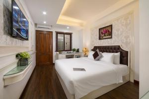 a bedroom with a large white bed and a window at TrangTrang Boutique Hotel in Hanoi