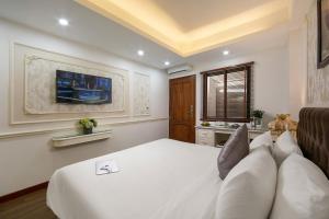 a bedroom with a large white bed and a window at TrangTrang Boutique Hotel in Hanoi