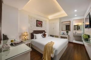a bedroom with a large white bed and a desk at TrangTrang Boutique Hotel in Hanoi