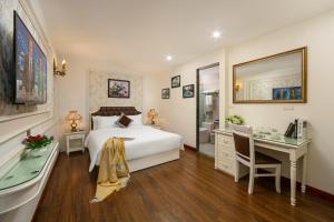 a bedroom with a bed and a desk and a bed and a sink at TrangTrang Boutique Hotel in Hanoi +40 photos