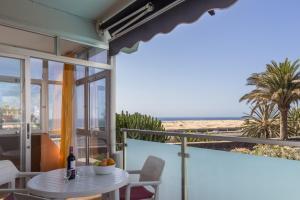 een balkon met een tafel en een fles wijn bij Alsol Patricio in Playa del Inglés