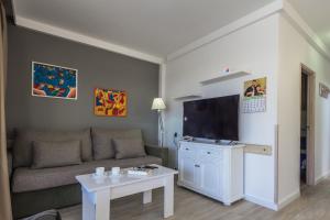 een woonkamer met een bank en een flatscreen-tv bij Alsol Patricio in Playa del Inglés
