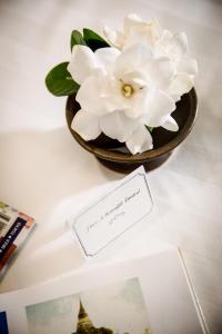 a vase filled with white flowers on a table at Na Nirand Romantic Boutique Resort in Chiang Mai