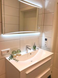 y baño con lavabo y espejo. en Ferienwohnung Domizil am Delft Emden, en Emden