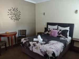 a bedroom with a bed and a table and a chair at Lilacs Waterfront Villas & Cottages in Albany