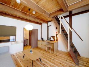 Großes Zimmer mit einem Tisch und einer Treppe in der Unterkunft NIPPONIA HOTEL Takehara Saltworks Town in Takehara