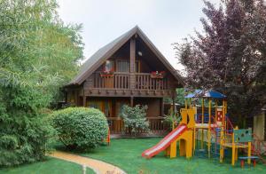 una casa con un parque infantil delante de ella en Gorny Ruchej, en Hora
