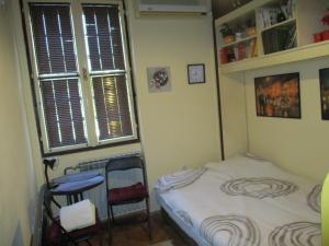 niewielka sypialnia z łóżkiem i oknem w obiekcie Aprtman Sonja 2 w Belgradzie
