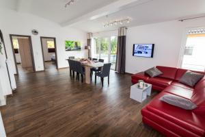 Una sala de estar con un sofá rojo y una mesa. en Ferienwohnung La Vita, en Winterberg